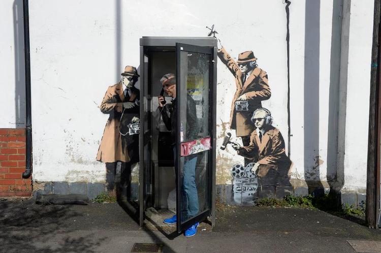 grafittikunst. I april malede Banksy denne gruppe typiske 1950'er-agenter der lytter til en telefonboks i byen Cheltenham nordvest for London. 
