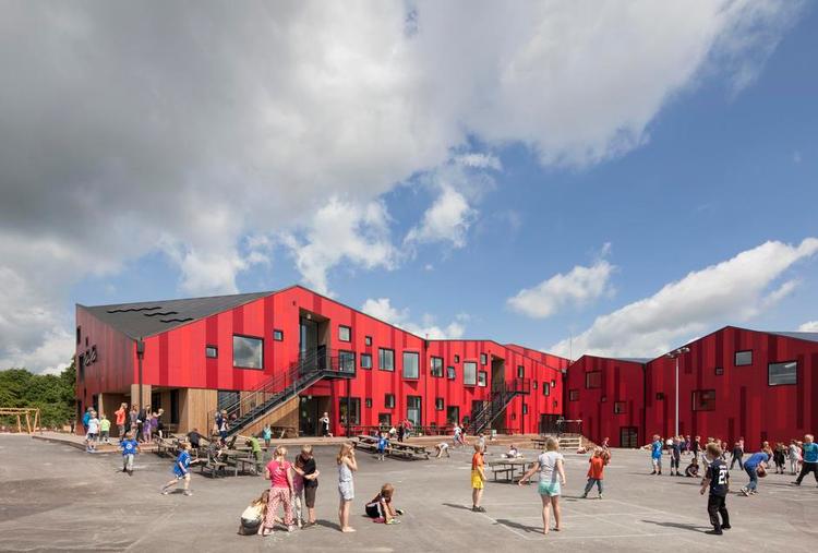 Nuancer. Facadens plader i forskellige røde nuancer er tænkt som en reference til egnens røde murstenshuse. Snart bliver asfaltpladsen også dækket af et landskab i kulørt faldgummi. 