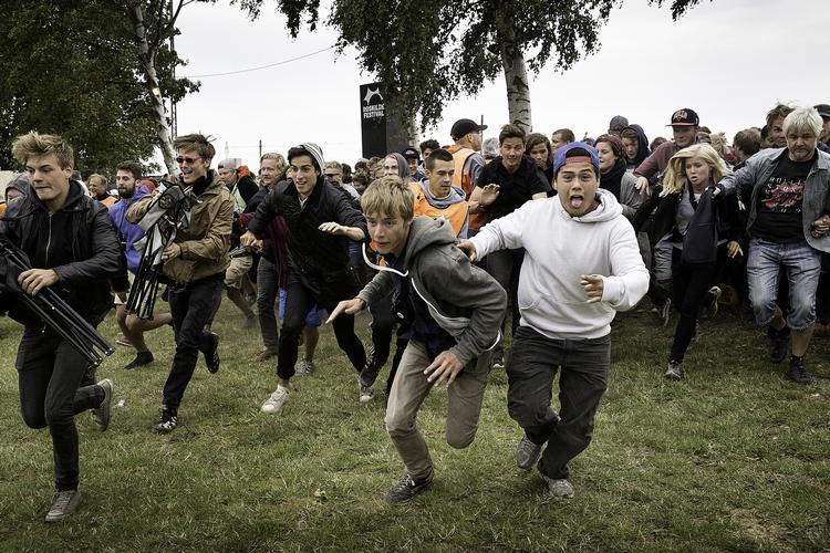 Roskilde-publikummet løber over  festival-pladsens grønne græs. 