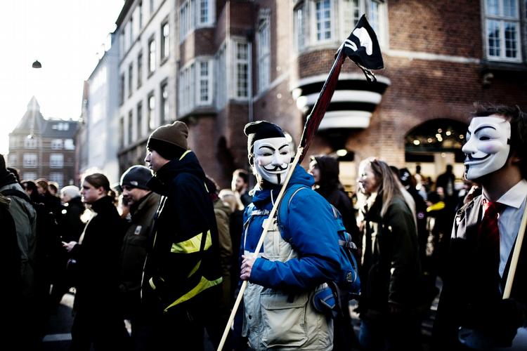Ukendt. De fire tiltalte i sagen er medlemmer af en dansk afdeling af gruppen Anonymous, som ifølge anklager Ebbe Arentoft blandt andet kendetegnes ved, at de bærer den ikoniske Guy Fawkes-maske, som ses ovenfor. Billedet er taget ved en stor demonstration mod den omstridte ACTA-lov i 2012. 