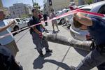NEDSLAG. Sprængstofeksperter fjerner resterne af en palæstinensisk raket, der blev skudt ned af det israelske forsvar, fra gade i Tel Aviv. 
