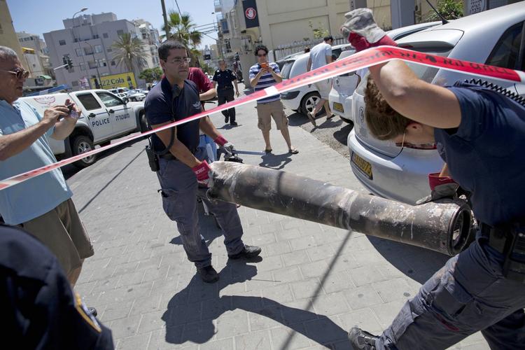 NEDSLAG. Sprængstofeksperter fjerner resterne af en palæstinensisk raket, der blev skudt ned af det israelske forsvar, fra gade i Tel Aviv. 