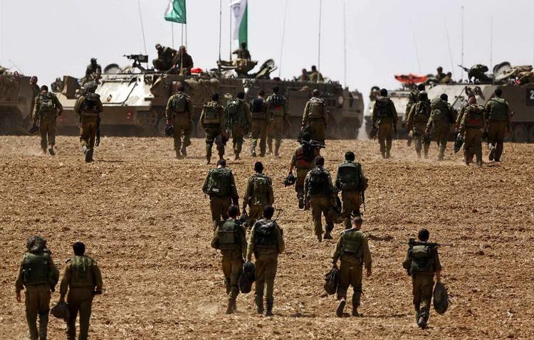 grænsen. Foreløbig har israelerne ikke vist tegn på at mildne de seneste dages aktioner mod palæstinenserne. Her er israelske soldater på vej til at indtage nye positioner langs grænsen mellem Israel og Gaza. 