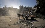 spøgelsesby. En palæstinenser trækker et æsel foran sig forbi et område, der er smadret efter et af mange israelske luftangreb. I øjeblikket er der ramadan, og normalt er folk ude i gaderne om aftenen for at højtideligholde den muslimske fastemåned. Men ikke nu, hvor israelske luftangreb i en uge har præget Gazastriben og kostet mindst 192 mennesker livet. 