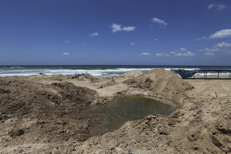 Konflikt. Et hul efter nedslag fra israelske granater for to dage siden på en strand ved Khan Younis på Gaza-striben. Fire børn er nu dræbt efter nye bombeangreb på strandhytter i Gaza. 