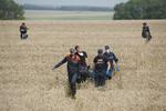 Nedstyrtning. Redningsfolk bærer lig væk fra det område i det østlige Ukraine, hvor et fly fra Malaysia Airlines torsdag aften styrtede ned. Mange af ofrene var hollændere og deres landsmænd er rasende over beretninger, om at lig er blevet fjernet fra området. 