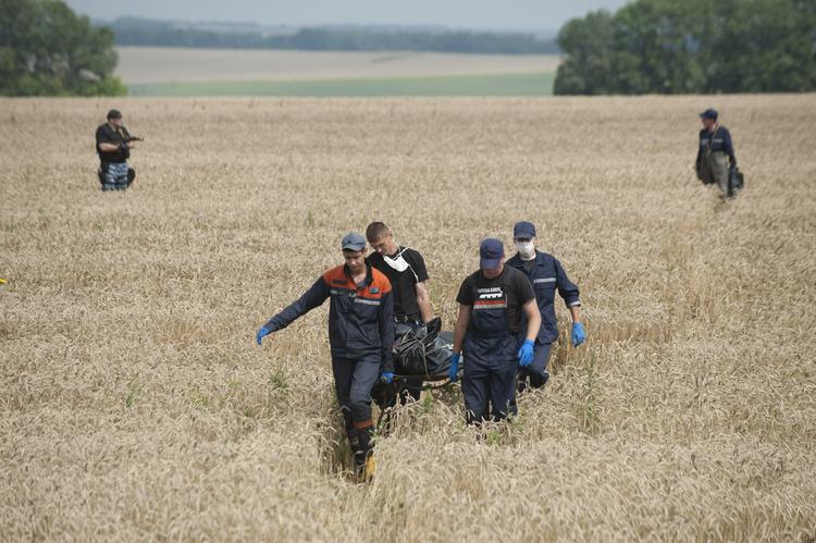 Nedstyrtning. Redningsfolk bærer lig væk fra det område i det østlige Ukraine, hvor et fly fra Malaysia Airlines torsdag aften styrtede ned. Mange af ofrene var hollændere og deres landsmænd er rasende over beretninger, om at lig er blevet fjernet fra området. 