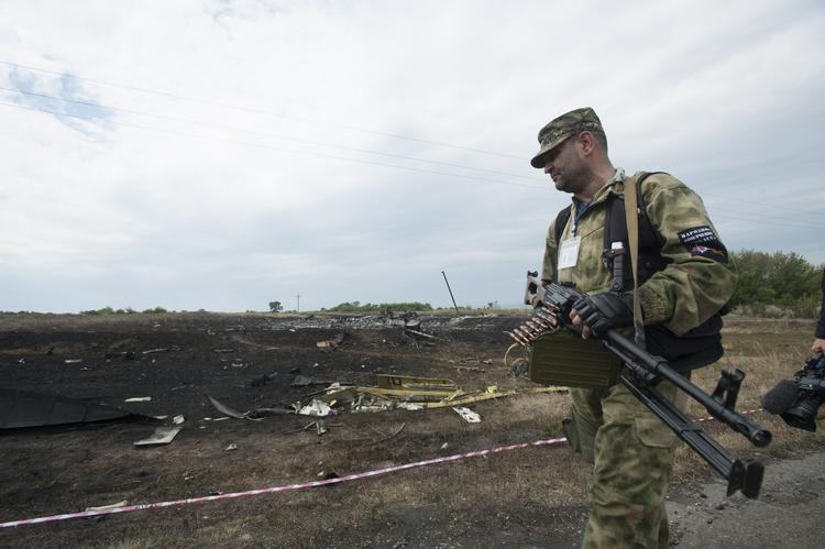 Bevæbnet. En pro-russisk militssoldat holder vagt ved nedstyrtningsstedet efter flyulykken i det østlige Ukraine. David Cameron mener, at Rusland på grund at støtten til separatisterne bærer et stort ansvar for hvad der angiveligt er en nedskydning af et civilt passagerfly. 