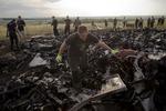 Oprydning. En mand leder efter ligrester i det udbrændte vrag efter flyet MH17, der formentlig blev skudt ned over ukrainsk luftrum. 