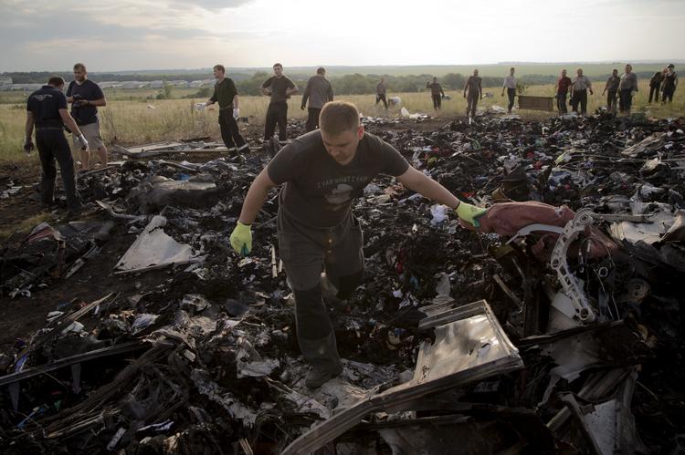 Oprydning. En mand leder efter ligrester i det udbrændte vrag efter flyet MH17, der formentlig blev skudt ned over ukrainsk luftrum. 