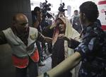 Gaza. Palæstinensere eskorterer en såret kvinde ind til skadestuen på Shifa Hospital i Gaza by. 