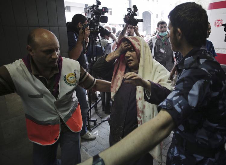 Gaza. Palæstinensere eskorterer en såret kvinde ind til skadestuen på Shifa Hospital i Gaza by. 