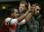 Hilsen. Arsenals offensivspiller Theo Walcott markerer her til publikum, at han scorede til 2-0 mod ærkerivalerne fra Tottenham i en FA Cup-kamp i januar. På billedet bliver han fragtet på en båre. 