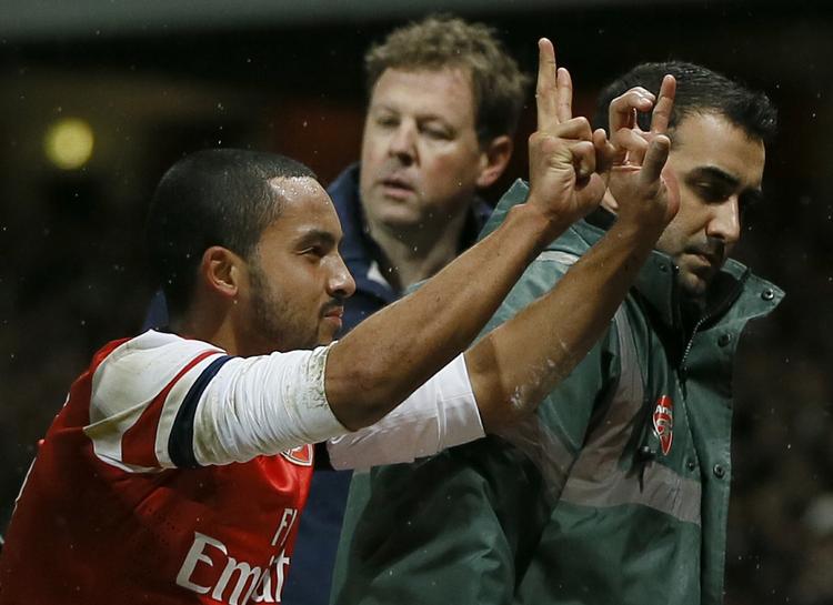 Hilsen. Arsenals offensivspiller Theo Walcott markerer her til publikum, at han scorede til 2-0 mod ærkerivalerne fra Tottenham i en FA Cup-kamp i januar. På billedet bliver han fragtet på en båre. 