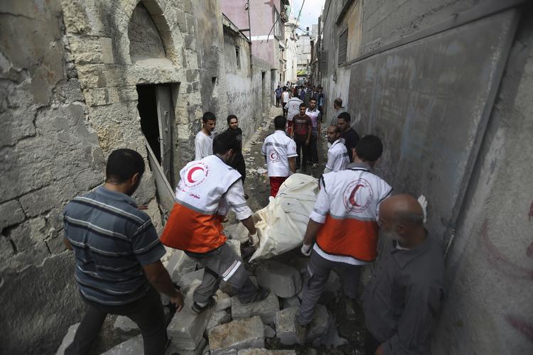 Ødelæggelse. Palæstinensere bærer et lig fundet i et ødelagt hjem efter dagens bombardementer i Gaza. 
