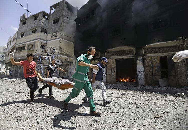 Kaos. Hjælpearbejdere bærer et offer for de israelske bombardementer i det nordlige Gaza i går. 