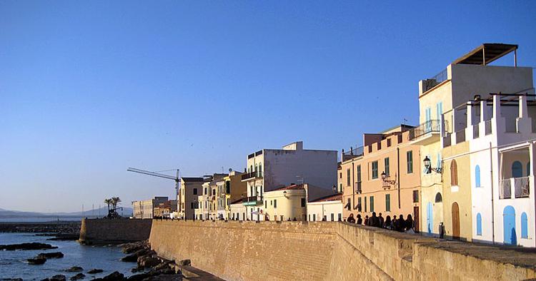 Beskyttelse. De mure, der engang beskyttede Alghero mod pirater, lyser i dag honninggult i den nedgående sol. 