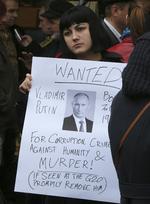 Protest. En kvinde holder et skilt, der opfordrer til anholdelse af Vladimir Putin for Ruslands støtte til oprørere, der mistænkes for at nedskyde det malaysiske fly med flere australske statsborgere om bord. 