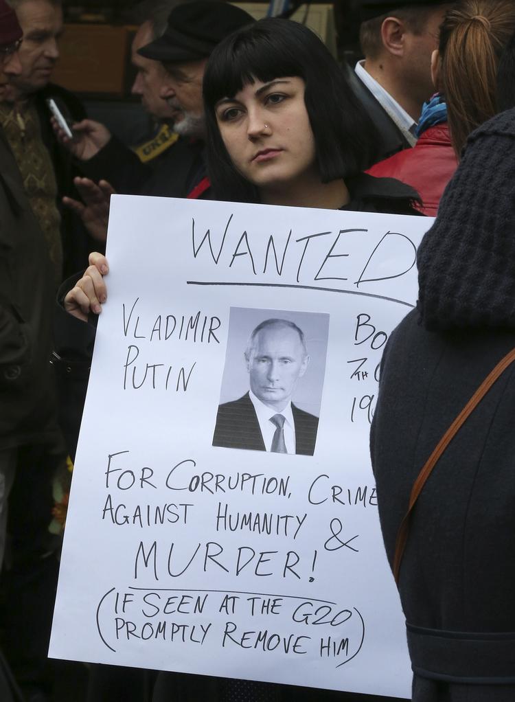 Protest. En kvinde holder et skilt, der opfordrer til anholdelse af Vladimir Putin for Ruslands støtte til oprørere, der mistænkes for at nedskyde det malaysiske fly med flere australske statsborgere om bord. 