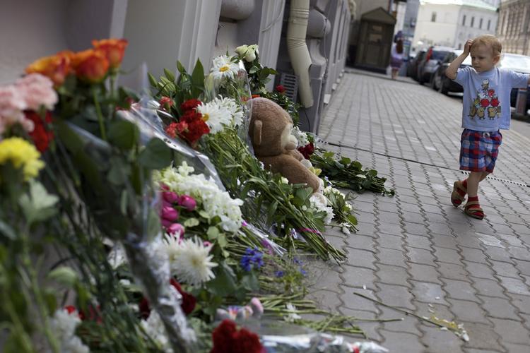 Medfølelse. En dreng passerer den hollandske ambassade i Moskva, hvor russere har lagt blomster og bamser til minde om de mange hollændere, der er døde i flystyrtet i Ukraine. 