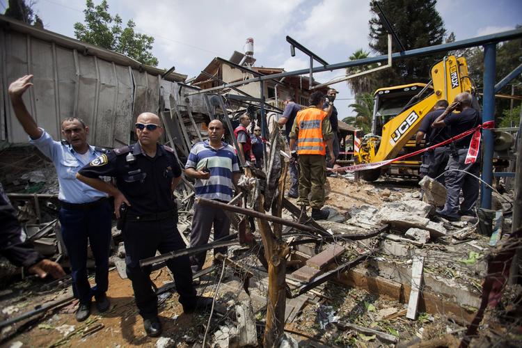 Angreb. Israelske politifolk ved et hus i en forstad til Tel Aviv , der er blevet ramt af en raket affyret fra Gaza. 