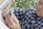 Pensionist med mobiltelefon i hånden