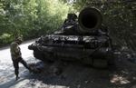 Kampe. En pro-russisk oprører står ved siden af en ødelagt ukrainsk tank tæt på Donetsk. Billedet er fra tirsdag. 