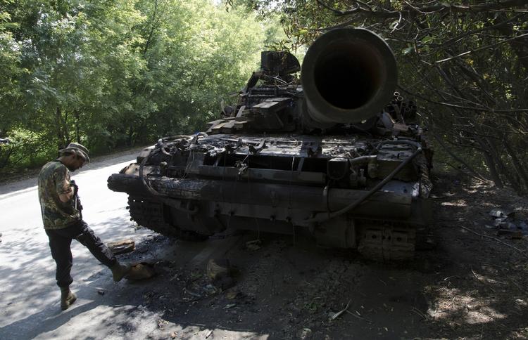 Kampe. En pro-russisk oprører står ved siden af en ødelagt ukrainsk tank tæt på Donetsk. Billedet er fra tirsdag. 