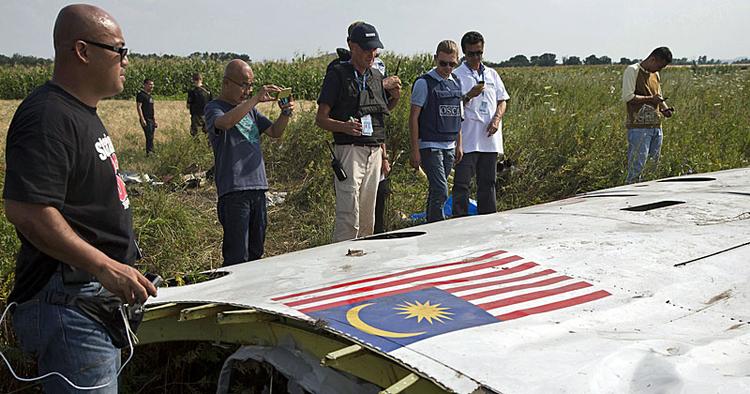 Tragedie. Malaysiske efterforskere og folk fra OSCE undersøger en del af det nedstyrtede fly MH17 i Ukraine. 