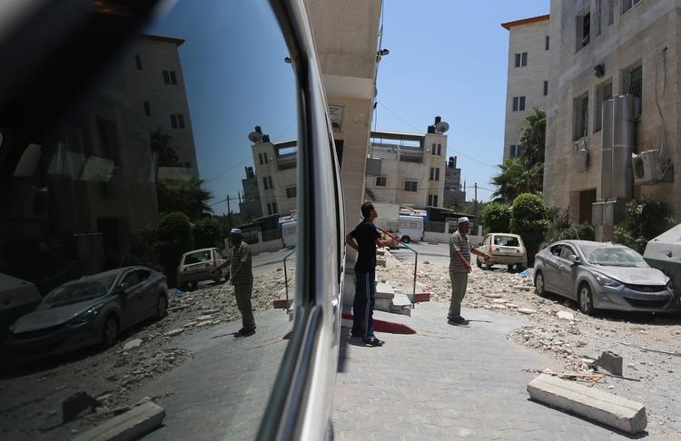 MURBROKKER. Hospitalet, hvor babyen i nat kom til verden uden sin mor, blev i mandags ramt af et israelsk luftangreb. Lokale palæstinensere undersøger her skaderne. 