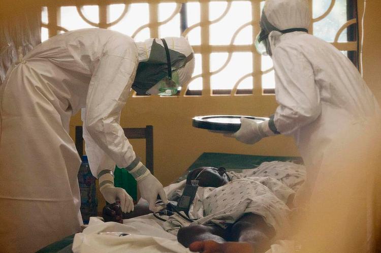 Behandler. På dette billede ses lægen Kent Brantly (til venstre) i færd med at behandle en patient for ebola på et hospital i Liberias hovedstad, Monrovia, inden han selv blev smittet med virussen og nu er under behandling. 