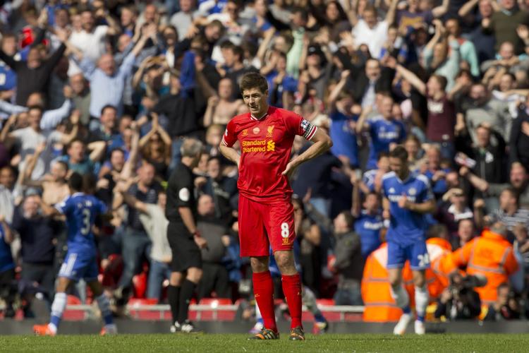 nedtur. Liverpools anfører, Steven Gerrard, ser jublende Chelsea-spillere i den kamp, hvor han gled og var skyldig i London-holdets førringsmål. 