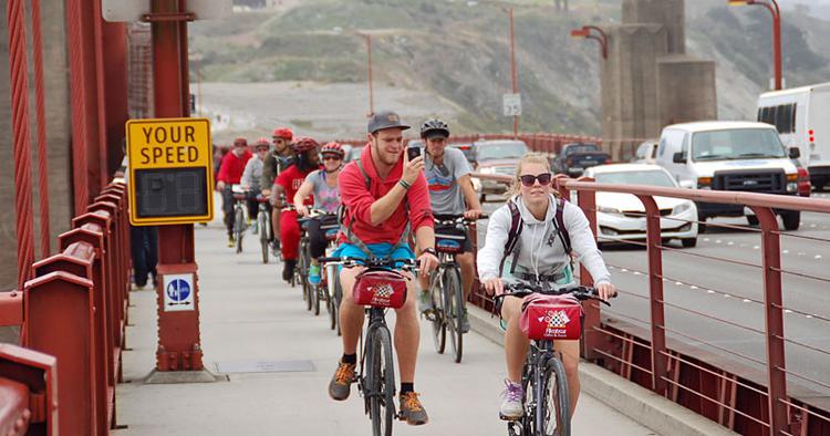 SELVPORTRÆT. Selfies - altså billeder man tager af sig selv med sin mobil eller kamera - bliver mere og mere populært. Her er en fyr i gang med at tage et på cykel på vej over Golden Gate Bridge i San Francisco. 