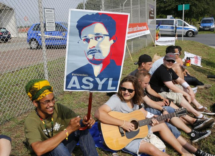 Flugt. Tyske demonstranter protesterer uden for en amerikansk militærbase i Griesheim, Tyskland. De vil have den tyske regering til at give Edward Snowden asyl. 