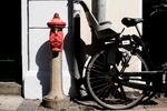Cykelparkering. Til venstre for nedløbsrøret kan man parkere sin cykel uden konsekvenser. Men på højre side af røret ligger en af Cykelstativets kunder, og her fjerner firmaet dem, så cyklerne ikke fylder foran facaden. 