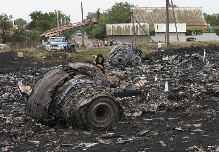 Flytragedie. En lokal kvinde går forbi vragdele fra det nedstyrtede Malaysian Airlines-fly. 