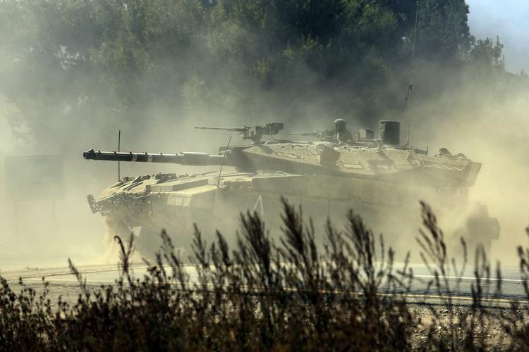 konflikt. En israelsk tank krydser en vej i det sydlige Israel på vej mod landets grænse til Gaza. Konflikten i området har kostet over 1.600 menneskeliv siden 8. juli. 