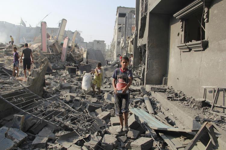 Ødelagt. Sådan så det ud i går i Rafah, som var udsat for hårde angreb. På billedet går en dreng igennem resterne af boliger. En skole er blevet ramt i dag, meddeler myndighederne. 