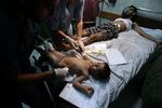 Behandling. En såret palæstinensisk dreng bliver behandlet på et hospital i Gaza. Han må dele sin seng med en voksen på hospitalets akutafdeling. 