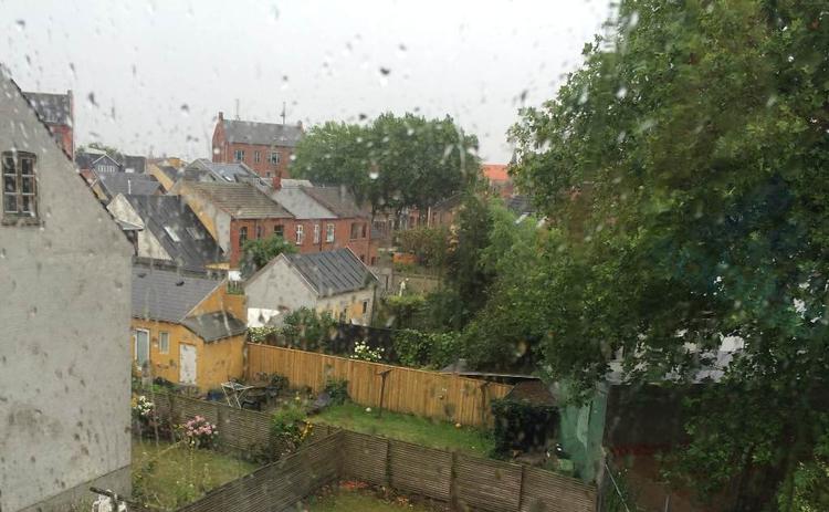 Fugtigt. Regnen styrter ned i store dele af landet og har fået brønddeksler til at skyde op af vejen flere steder. Udsigten her er fra Odense. 