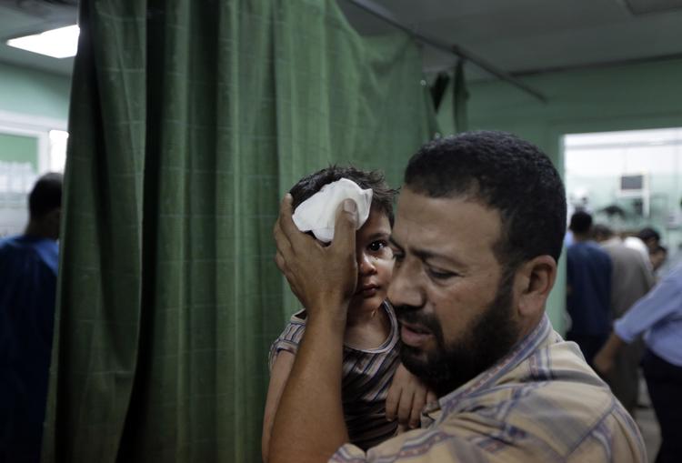 såret. En palæstinenser bærer en såret dreng ind på skadestuen i Kamal Adwan-hospitalet i Beit Lahiya i det nordlige Gaza. 
