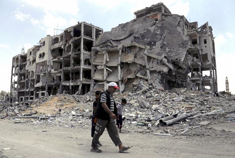 ødelæggelser. Palæstinensere passerer smadrede bygninger i byen Beit Lahiya i den nordlige del af Gazastriben. Flere af de 520.000 fordrevne har i dag benyttet sig af den midlertidige våbenhvile og er vendt tilbage til deres huse - eller resterne af dem. 