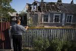 En lokal beboer kalder på sin nabo fra en beskadiget hus efter beskydning i Petrovsky-distriktet i byen Donetsk i det østlige Ukraine. 