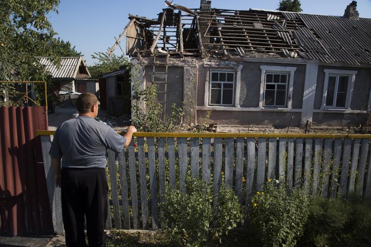 En lokal beboer kalder på sin nabo fra en beskadiget hus efter beskydning i Petrovsky-distriktet i byen Donetsk i det østlige Ukraine. 