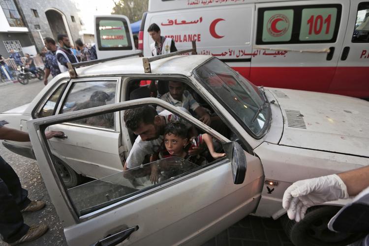 Tusindvis. Shifa-hospitalet er det største i Gaza og tusindvis af sårede og døde er ankommet til hospitalet i den seneste måned. Her ses en palæstinensisk mand, der bærer på et såret barn efter et missilangreb i byen. 