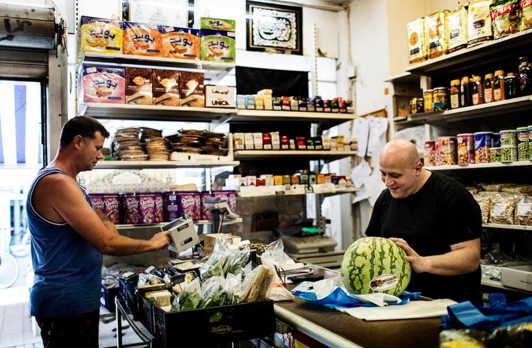 Kundekamp. Grønthandler Muhammed Hassoun mærker krisen, men er heldig at have faste kunder, »og så tilbyder jeg også nogle anderledes varer end supermarkederne«, siger han og slår en kundes varer ind med et »63 kroner – 60 for dig«. 