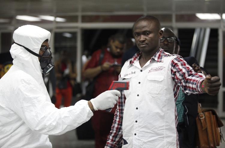 Vira. En nigeriansk toldofficer kontrollerer for en uge siden en person ved lufthavnen i Lagos. Det var her, at en rejsende bragte den farlige smitte til byen. 