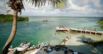 Presset. Badegæster hygger sig ved Caye Caulker i Belize. Strandbyen tiltrækker normalt backpackere med planer om at udforske Belize Barrrier Reef, der er på Unescos verdensarvsliste, men som er også er truet. 