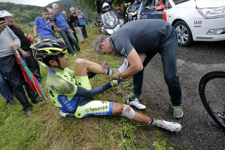 vuelta-klar. Alberto Contador hjælpes, mens tilskuere får et nærbillede af stjernen, efter styrtet i Tour de France, hvor spanieren brækkede skinnebenet. 