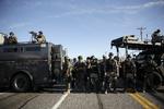 Optøjer. Sikkerheden er massiv i byen Ferguson i USA, efter at politiet lørdag skød og dræbte en ubevæbnet 18-årig afroamerikansk mand. 